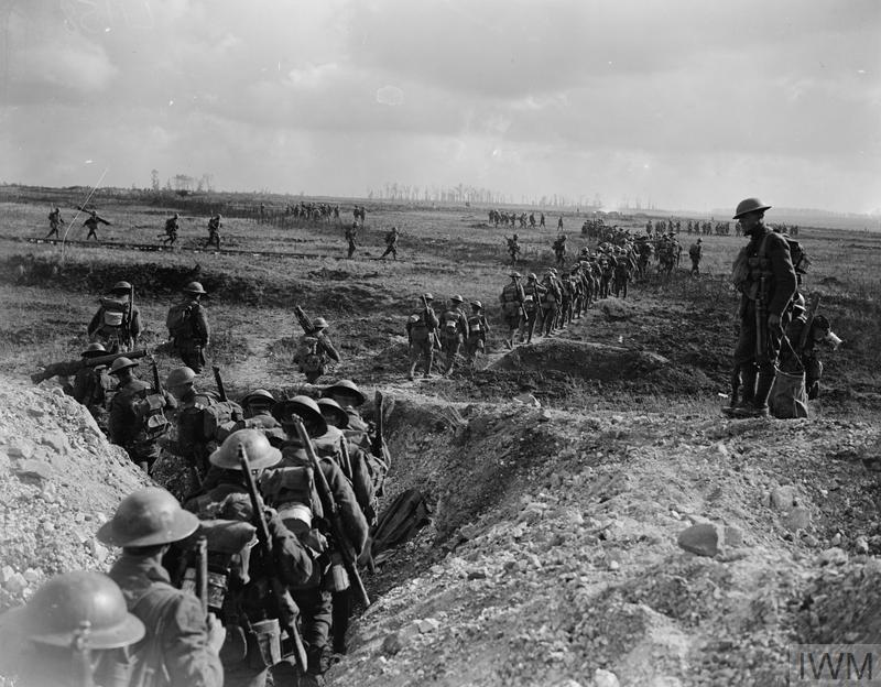 A column of Canadian soldiers navigates out of a movement trench onto open ground on the Western Front during Canada's Hundred Days.