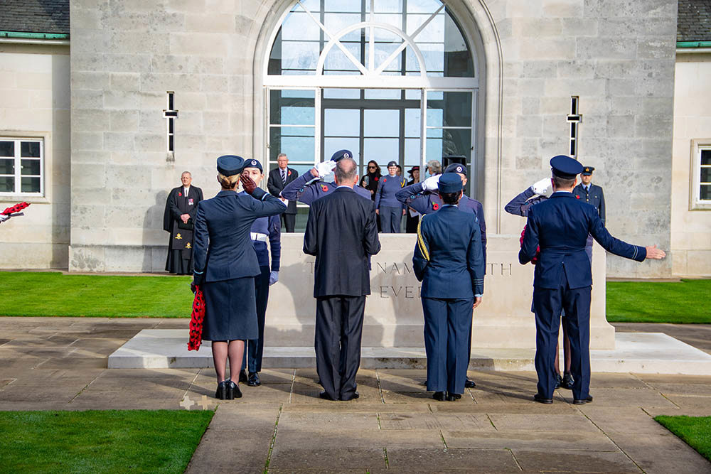 Cadets and Air Force officers salute wreaths during a ceremony at Runnymede Air Forces Memorial.