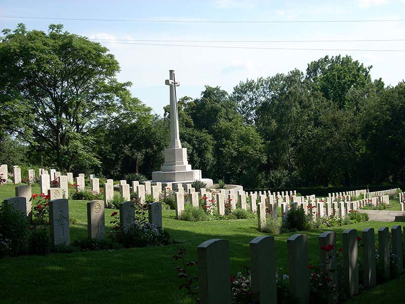 Headstones and cross of sacrifice at Poznan Old Garrison Cemetery