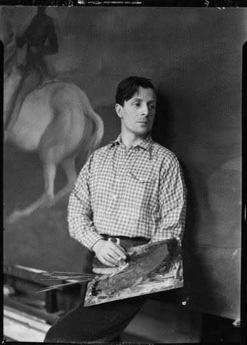 Rex Whistler posing with a palette in front of a painting of a man riding a horse