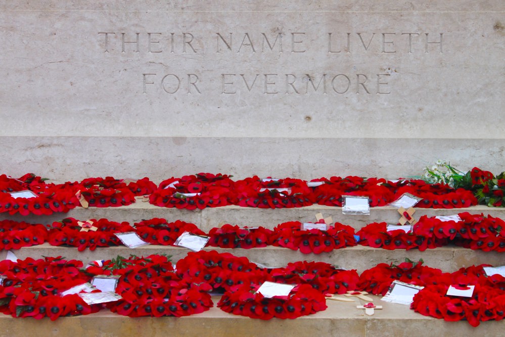 Poppy wreaths laid on a CWGC Stone of Remembrance