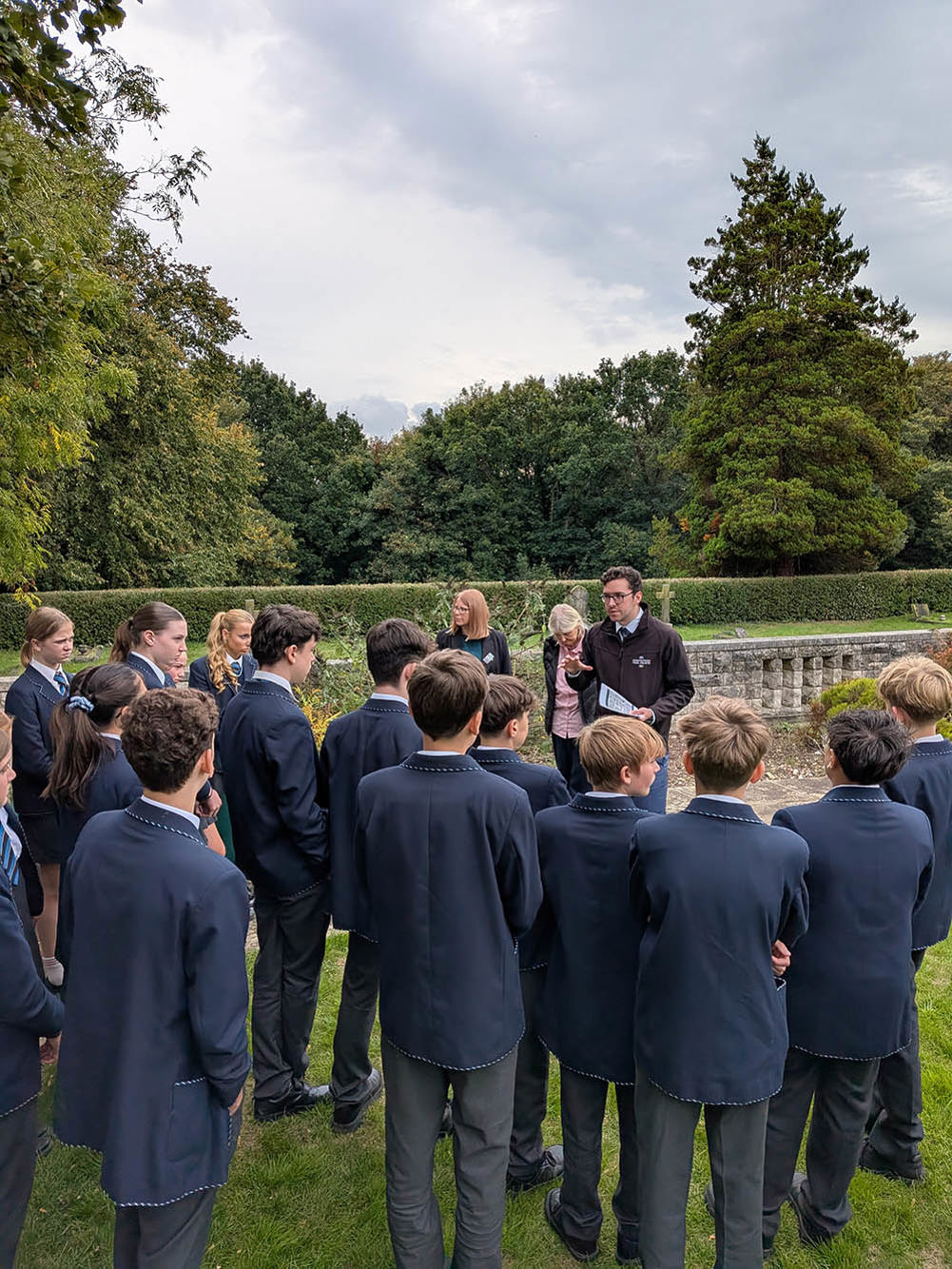 A CWGC Tour guide speaks to schoolchildren in a CWGC cemetery.