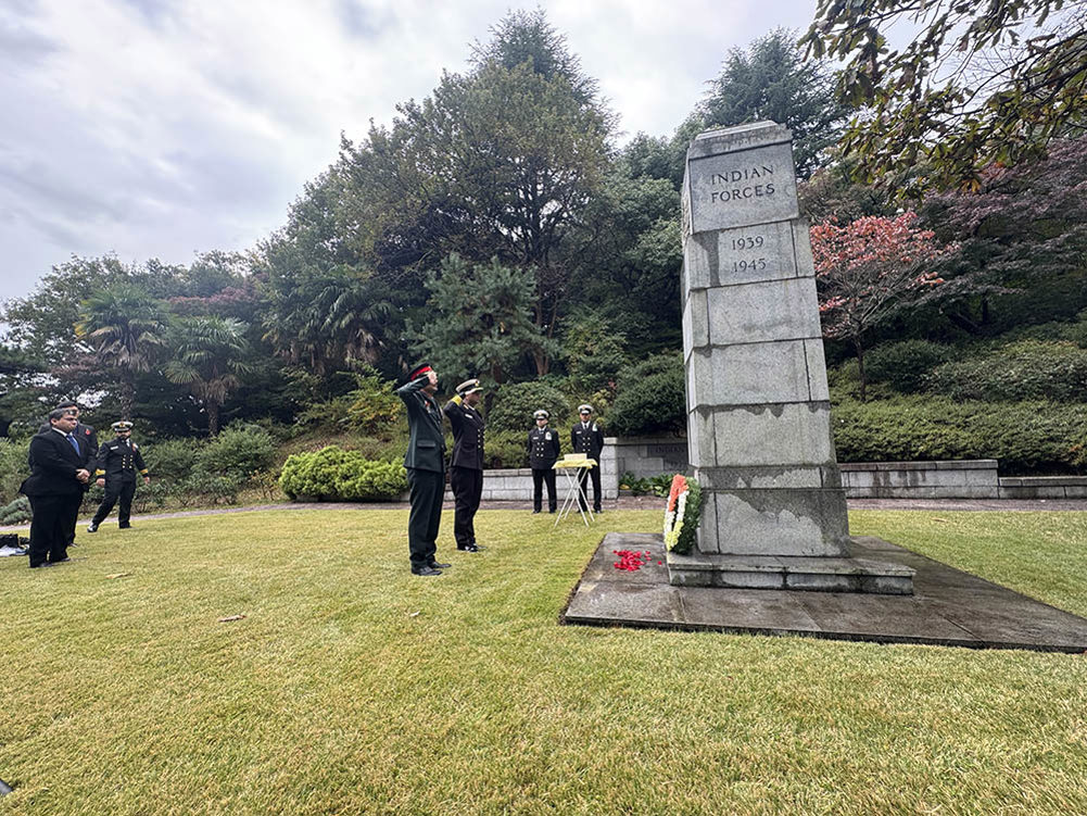 Military figures salute the Indian Forces Memorial in Yokohama War Cemetery.