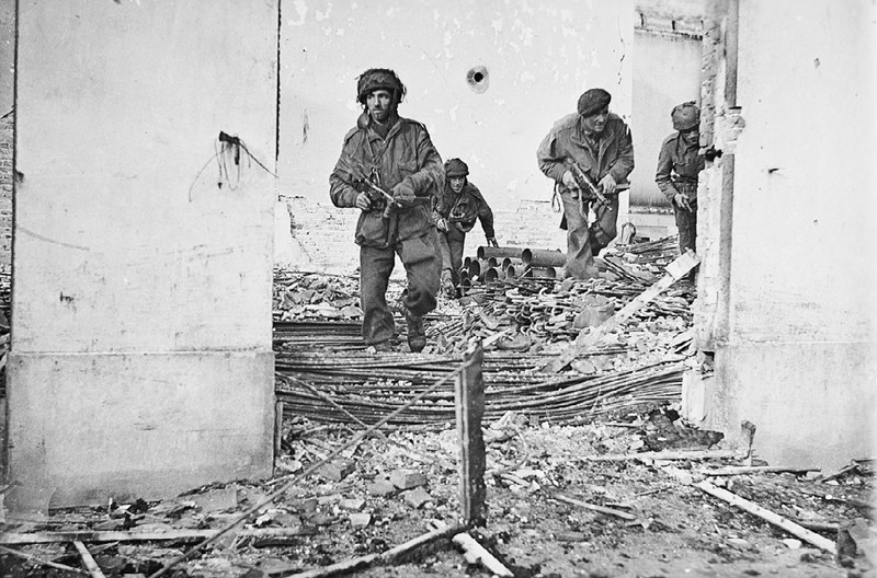 British paratroopers advance through a ruined building in Oosterbeek, Arnhem in a staged photo