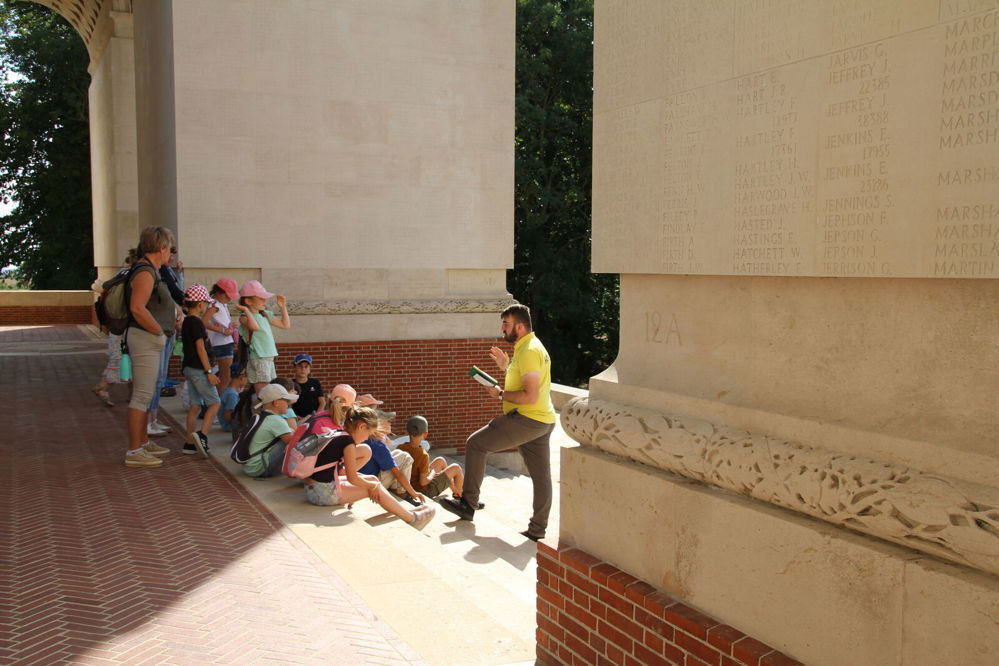 A CWGF guide speaking to a group of school children under the central arch of the Thiepval Memorial.