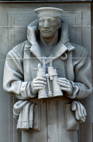 Close up of a sculpture of a sailor in a thick winter coat, sailing cap, and holding a pair of binoculars, at Portsmouth Naval Memorial.