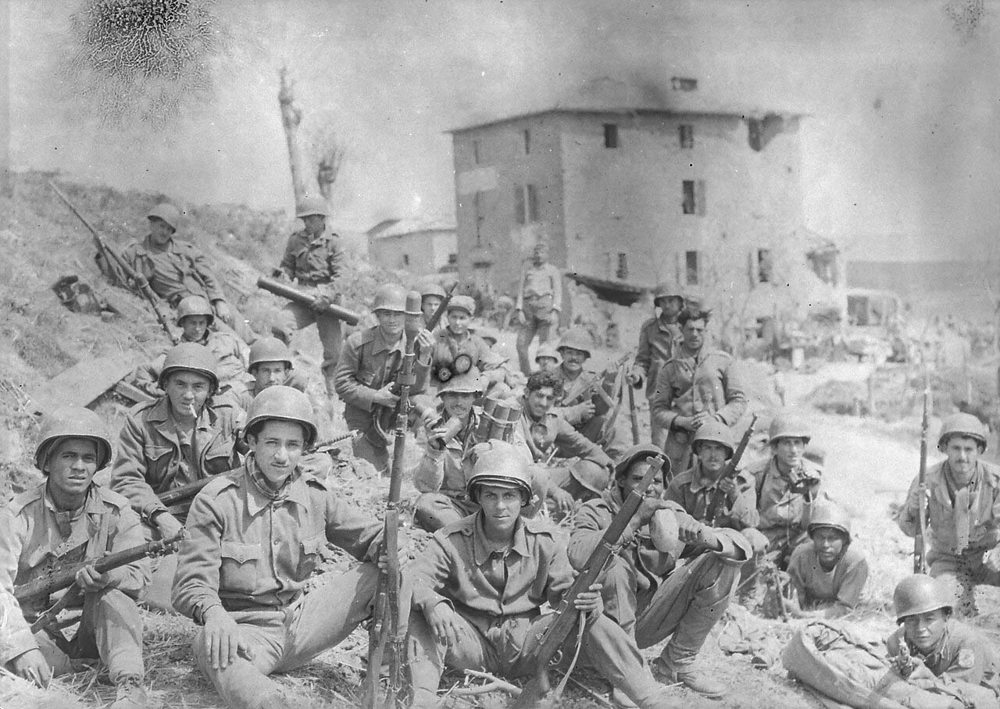 Brazilian soldiers pose for the camera in front of a ruined house in Italy during WW2.
