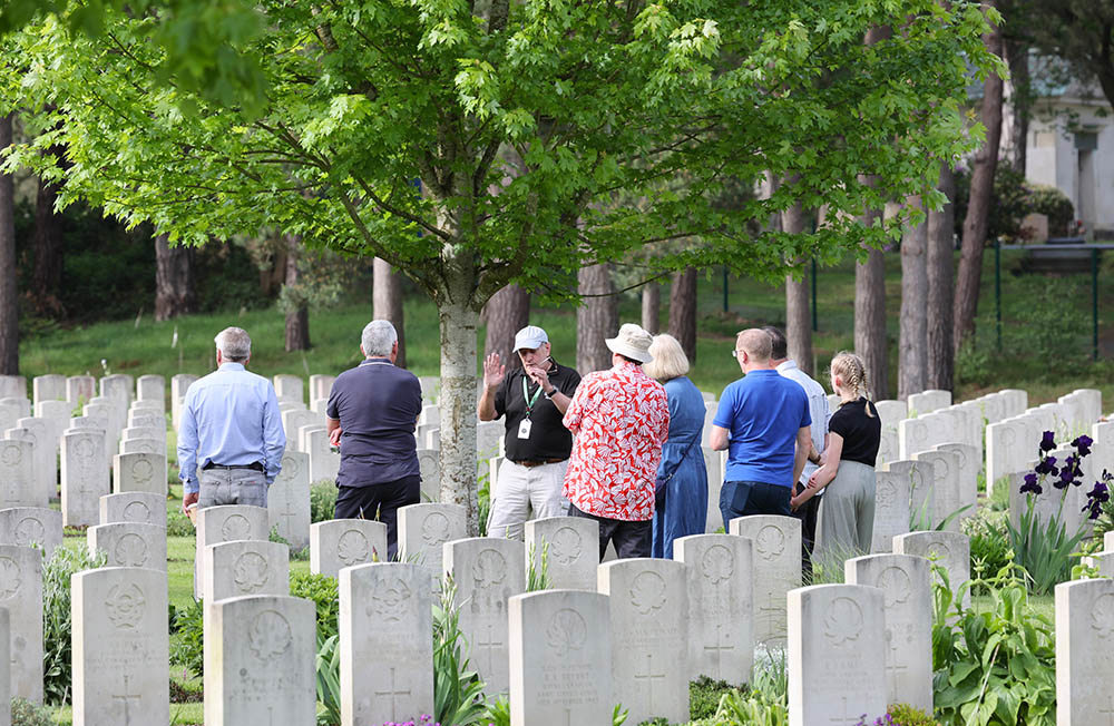 Tour guide showing visitors around a CWGC cemetery.