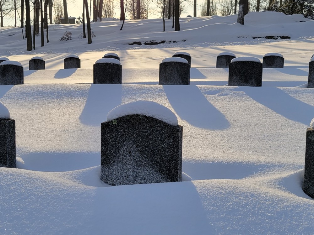 Rows of CWGC headstones blanketed by a thick layer of snow in Beechwood Cemetery, Canada.