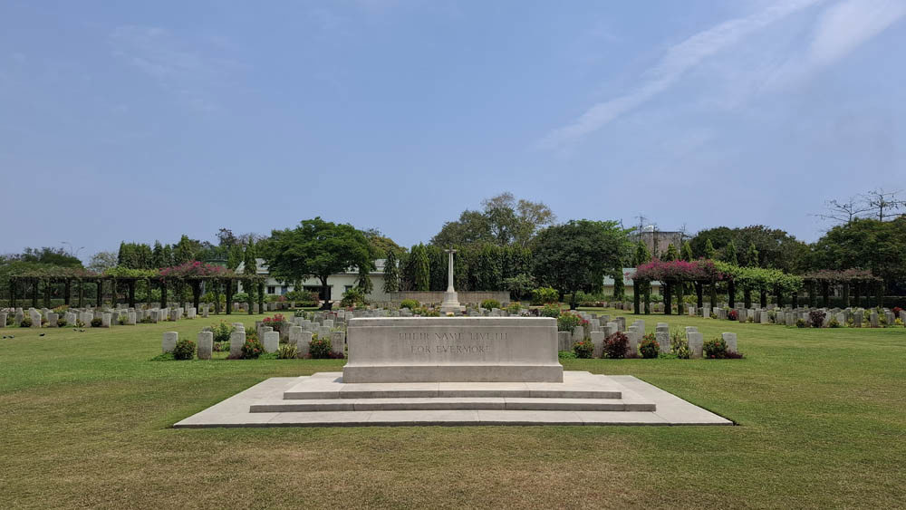 Madras Cemetery Stone of Remembrance facing towards cross of sacrifice under a clear blue sky.