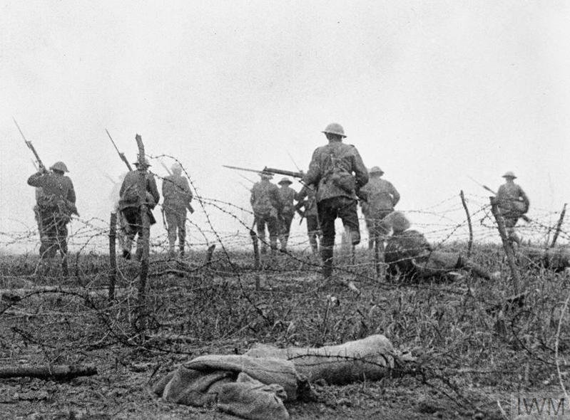 British soldiers advaning through barbed wire during a First World War offensive.