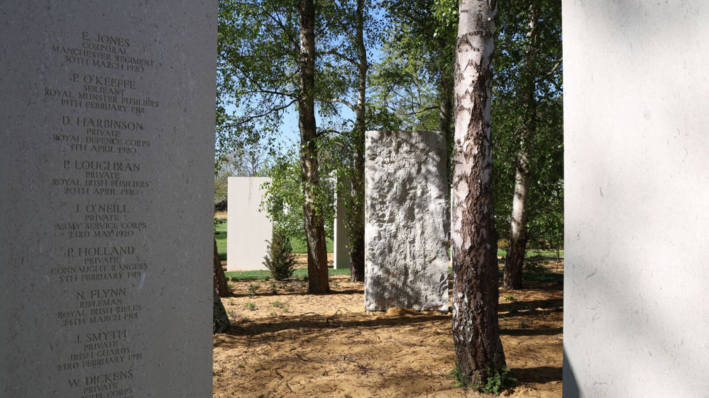 Shot of the memorial stelae among trees at Brookwood Military Cemetery. The names of several servicemen are visible etched into one of the limestone stelae in the foreground.