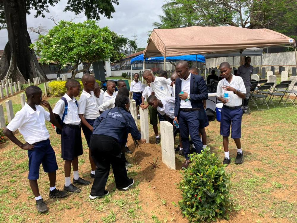Schoolchildren and a teacher on a tour of a CWGC cemetery in Sierra Leone.