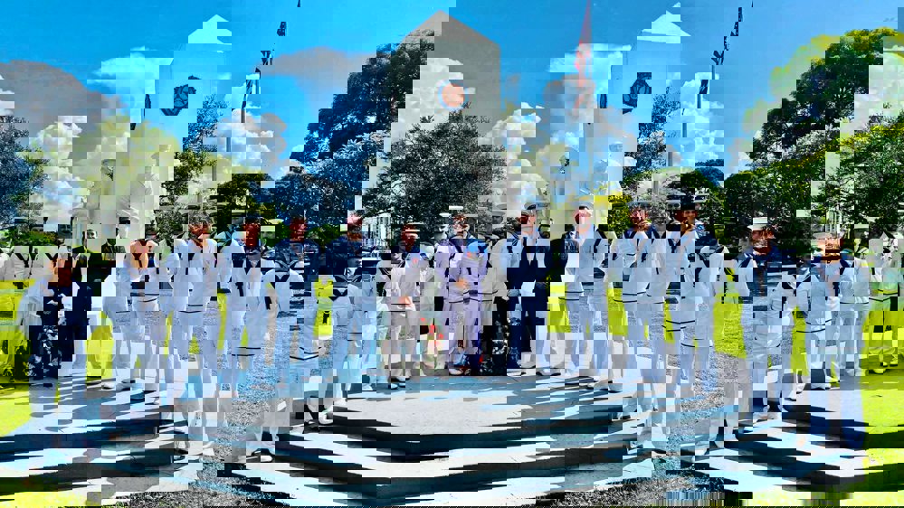 British Naval crewmen pose on the steps of an American naval memorial in their clean, crisp white naval uniforms, for Remembrance Day.