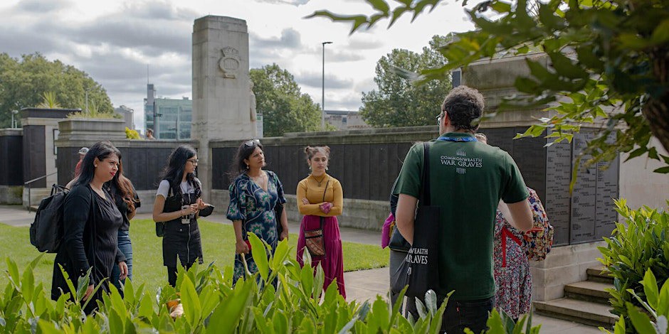 A tour guide giving a speech to attentive guests at the Tower Hill Memorial.