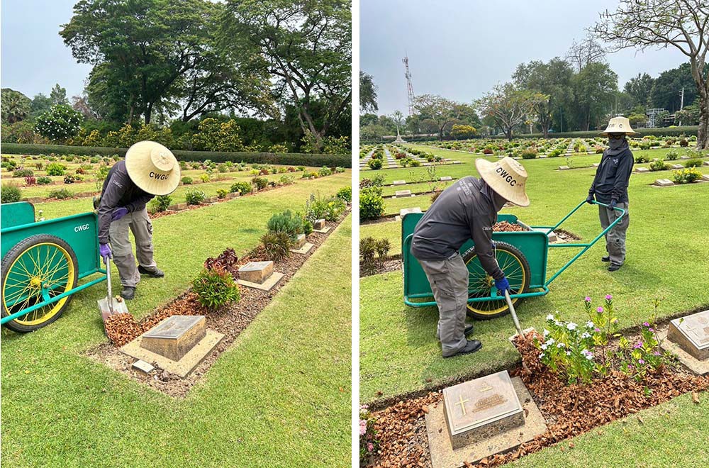 CWGC gardeners shovel coconut chips into the bedding of a plant border along a headstone row at Chungkai War Cemetery.