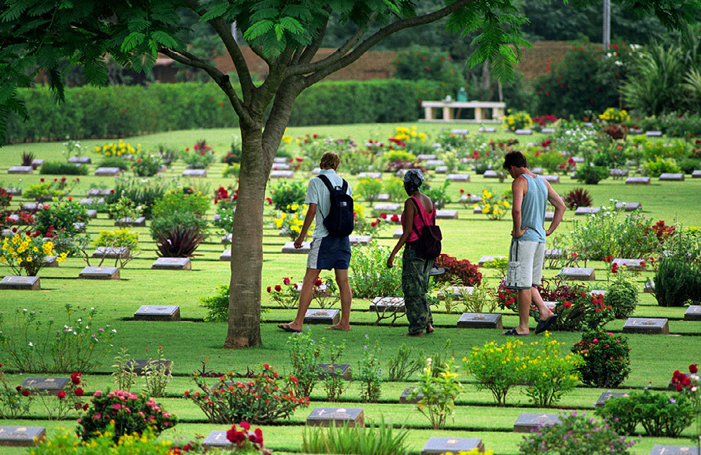 A trio of visitors inspecting war graves at Kanchanaburi War Cemetery.