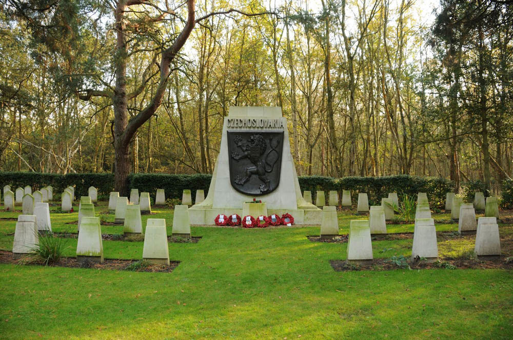 Czechoslovakian War Graves at Brookwood Military Cemeteries featuring rhomboid-shaped headstones. A central large monument, featuring a brozne heraldic device, is visible in the centre.