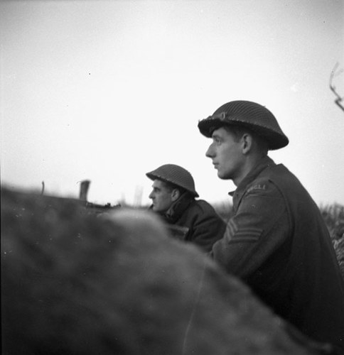 Two Canadian Soldiers sit in a slit trench in Italy during WW2.