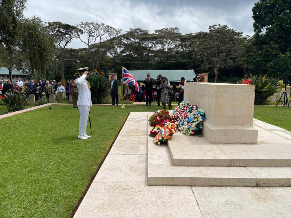 Indian Army Officer salutes the Stone of Remembrance at Nairobi War Cemetery as part of Remembrance Day 2025 Ceremonies. Many colorful flower wreaths have been laid at the base of the stone.