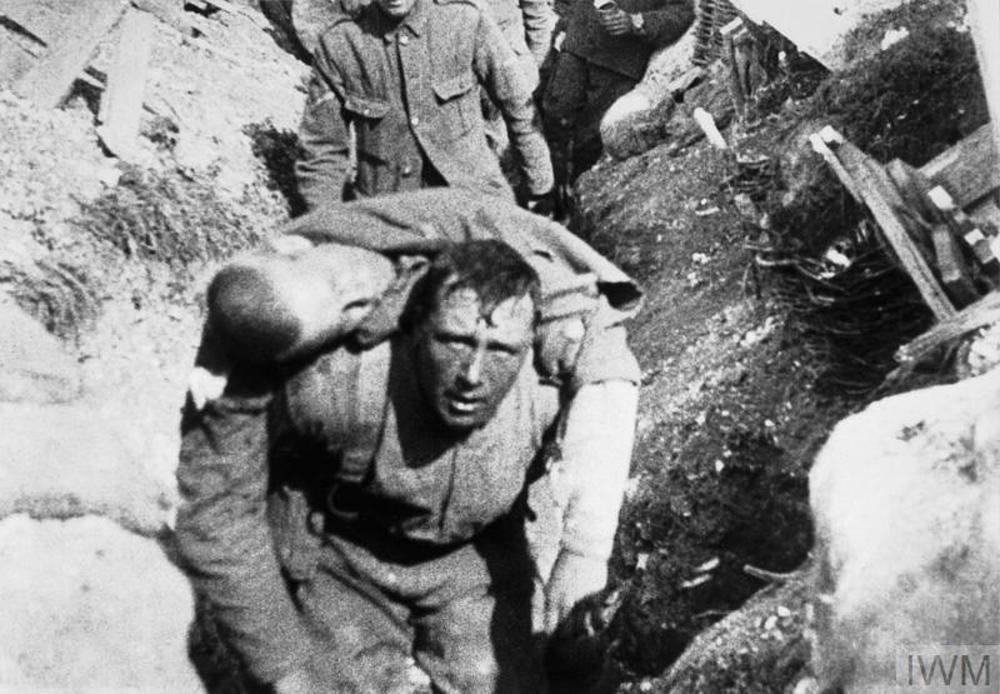 A British soldier carrying a wounded comrade down a trench network in a still from the film "The Battle of the Somme".