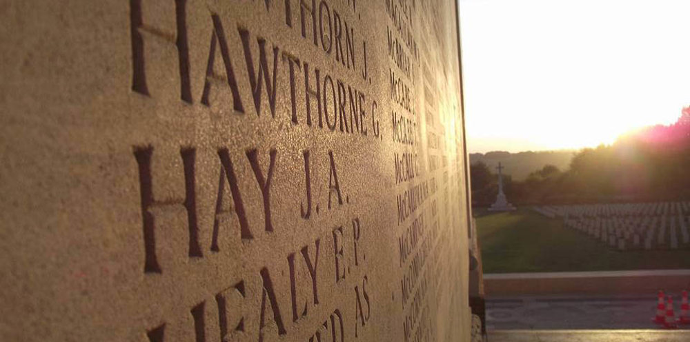 The sun shining on a memorial name panel at Thiepval Memorial to the Missing of the Somme.