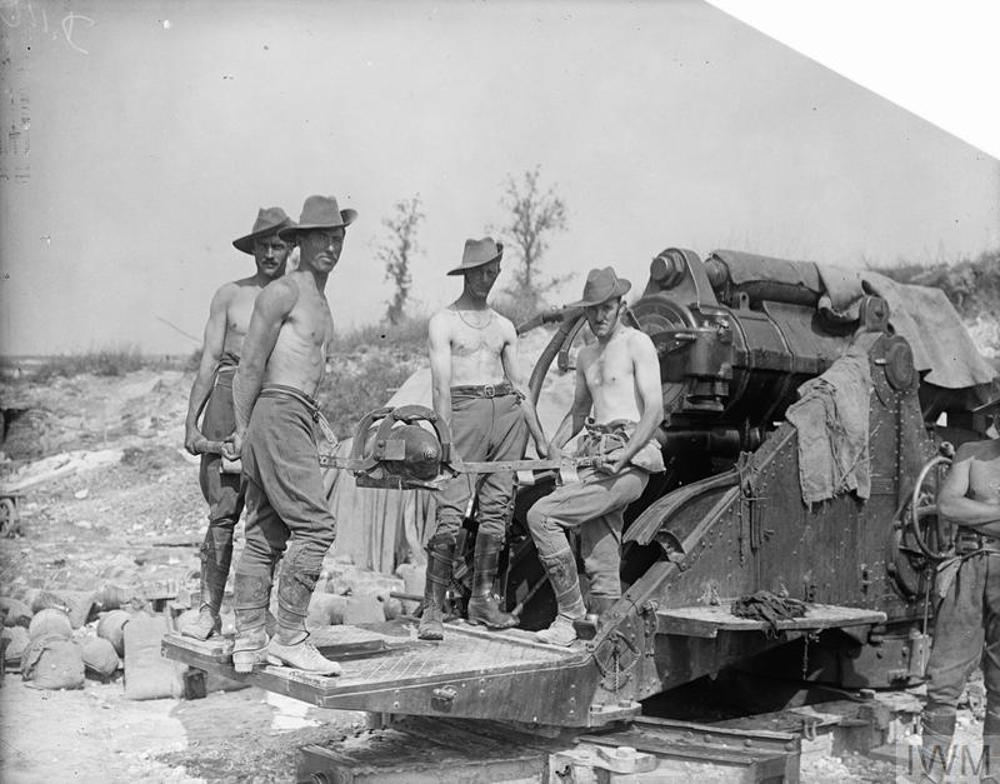 Shirtless Australian soldiers in Slouch Hats posing on the firing plate of a huge artillery gun during the Battle of the Somme,