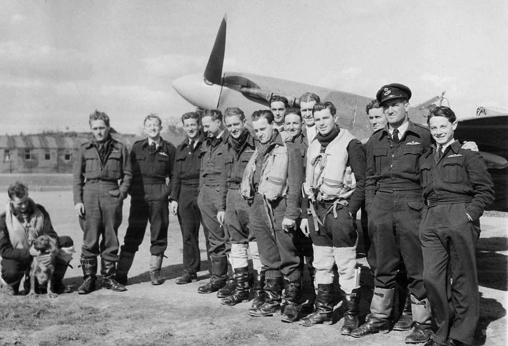 A black and white photo of RAF service people by a plane from our WW2 war records