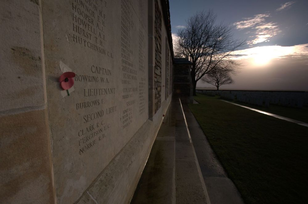 Close up of the Caterpillar Valley (New Zealand) Memorial showing name panels. A poppy has been taped to one of the name panels.
