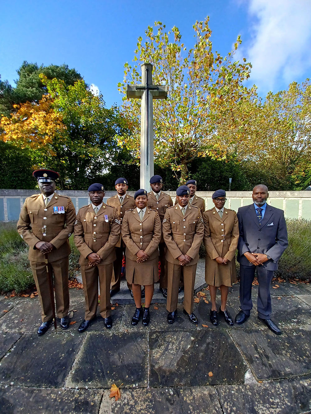 Black British Army personnel pose in front of the Cross of Sacrifice at Southampton Hollybrooke Memorial.