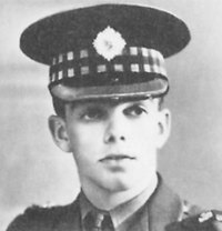 A black and white portrait photo of Charles Anthony Lyall VC. He is wearing the peaked officer's cap with tartan band of an officer in the Scots Guards.