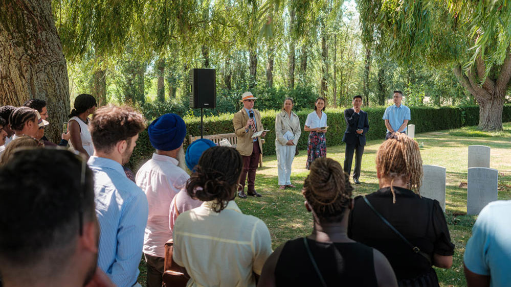 Crowds gather to listen to a speaker talk at Lijssenthoek Military Cemetery, Belgium.