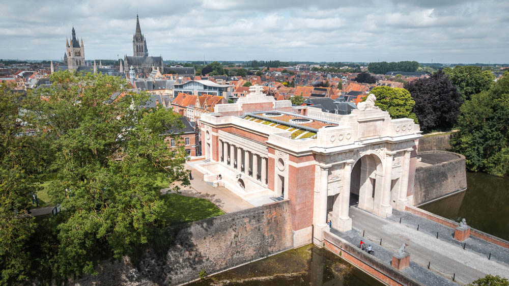 Ypres Menin Gate memorial with the spires of Ypres Cloth Hall and Cathedral visible in the background.