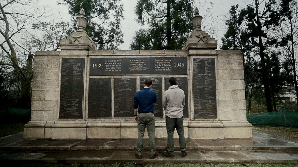 Two men inspect names on the Kohima Cremation Memorial