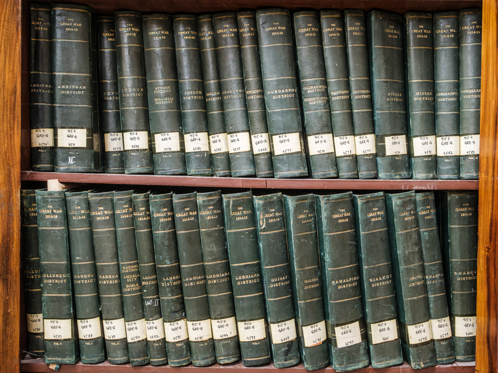 Leatherbound books placed on a shelf.