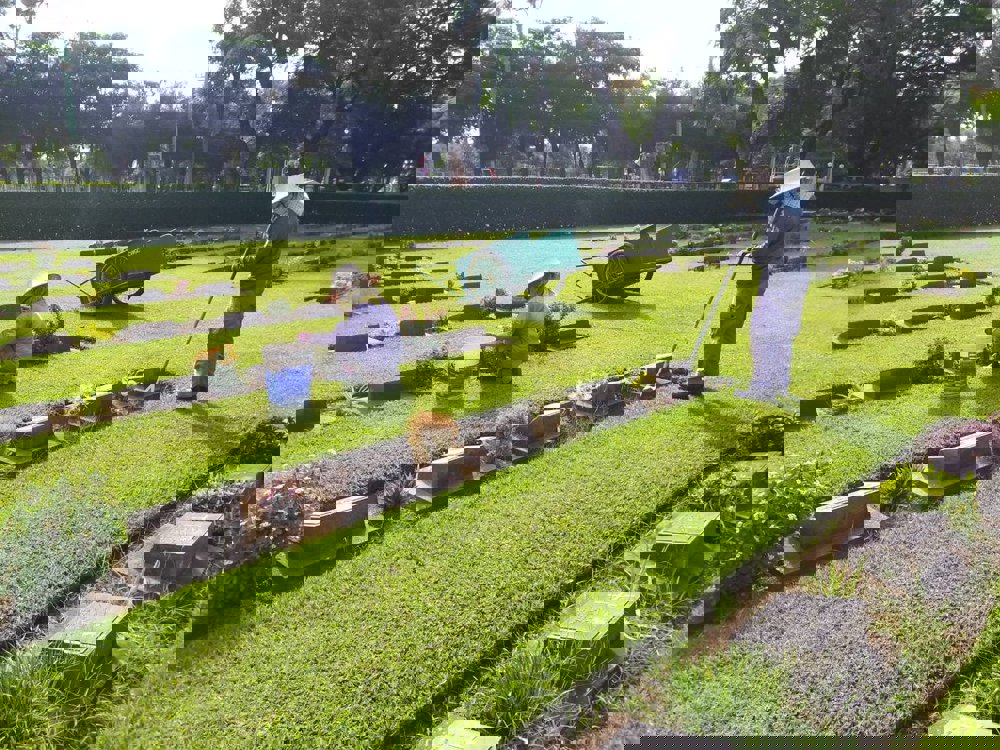 Gardeners working on planting and borders at Kanchanaburi War Cemetery.