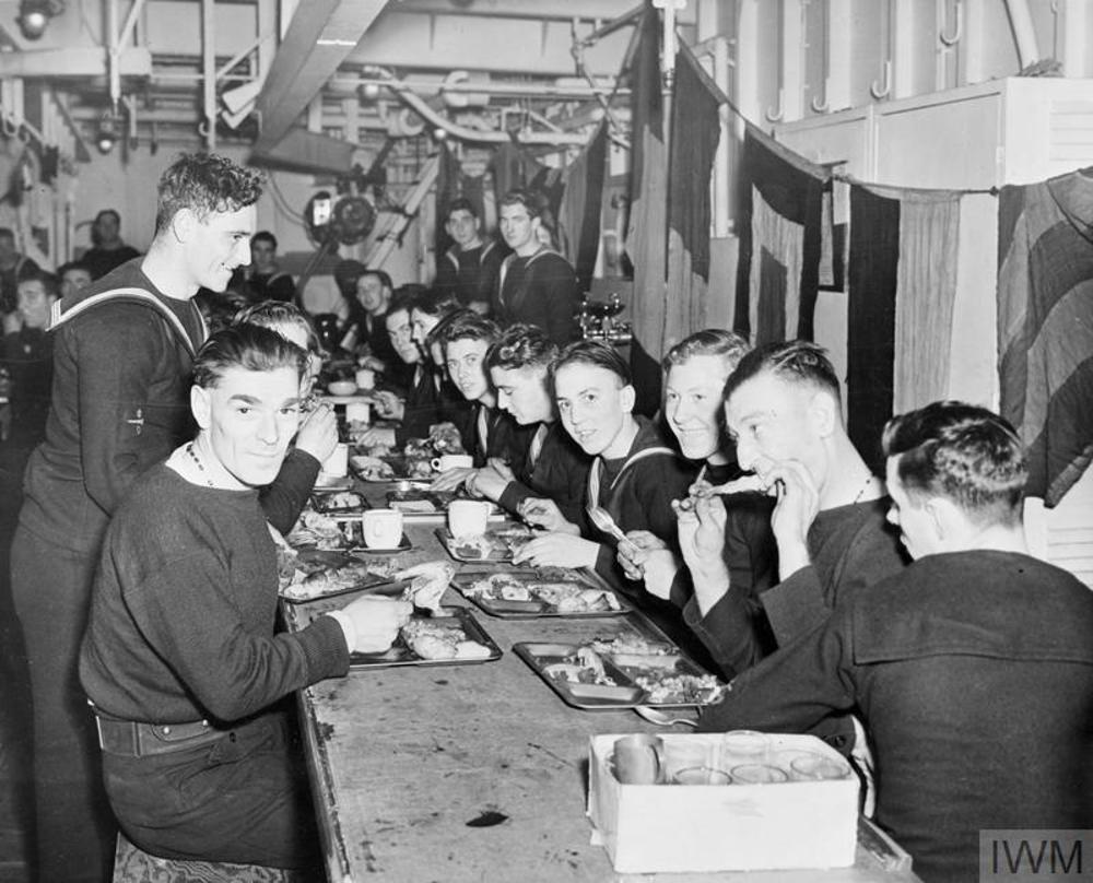 Sailors  eating special christmas dinners aboard an escort vessel during the Second World War.