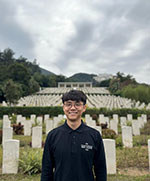 Peter Wong stands in front a CWGC Hong Kong Cemetery