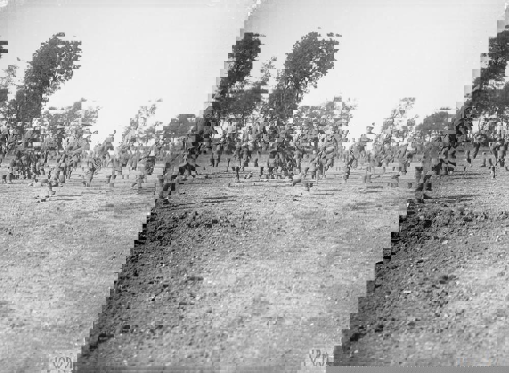British soldiers playing an imprompteu game of football on a patch of muddy ground on the Western Front during the First World War.