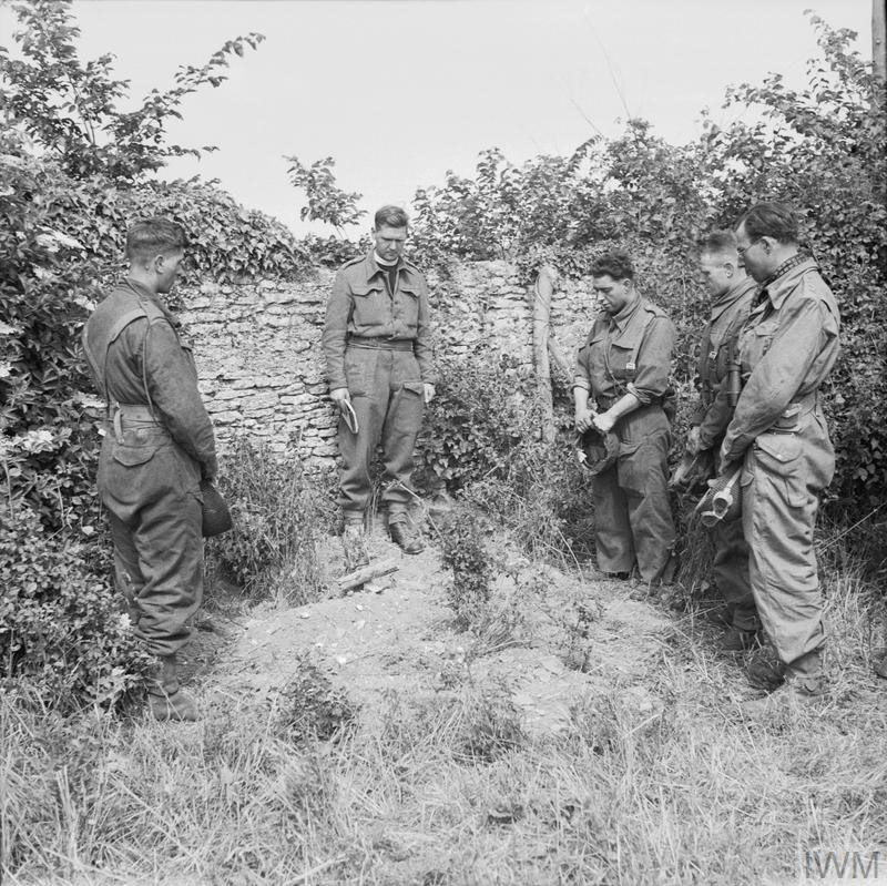 An army padre holds a small memorial suervice for a soldier killed in the Nomrandy campaign, circa June 7 1944.