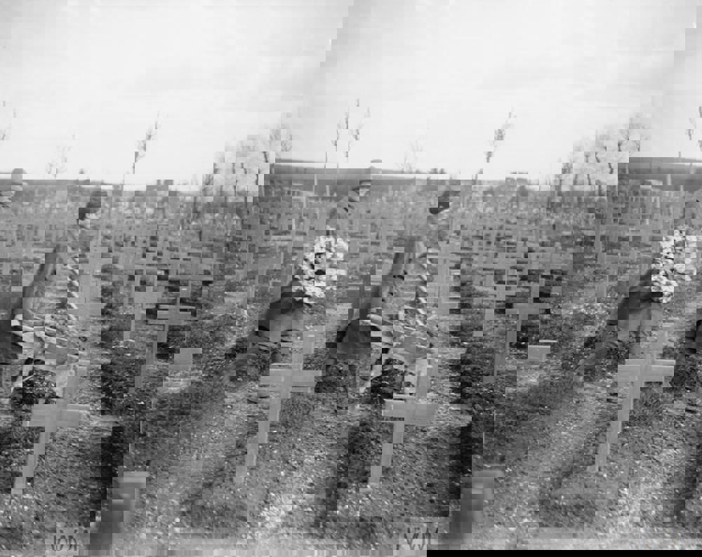 Women tending war graves at Abbeville Military Cemetery in 1918. Graves are marked with simple wooden cross markers.
