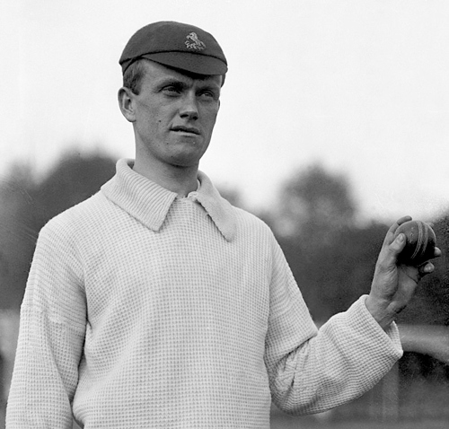 Charlie Blyth holding a cricket ball in his cricket whites and cap.