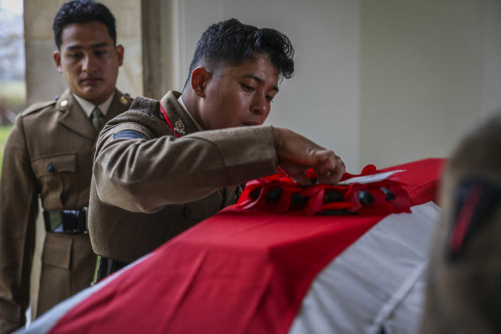 Cpl Gurung secures the wreath to the coffin of the unknown soldier prior to the burial.
