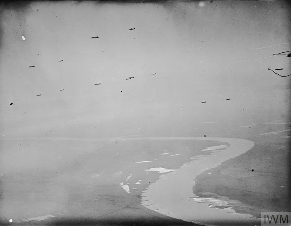 A train of gliders flyinh high over the River Rhine during the Allied river crossing in March 1944. The gliders are flying high in the sky with the river far below.