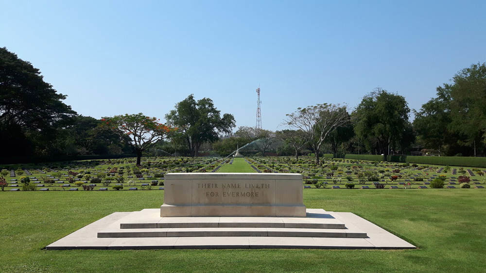 Stone of Remembrance overlooking the main path and grave plots at Chungkai War Cemetery.