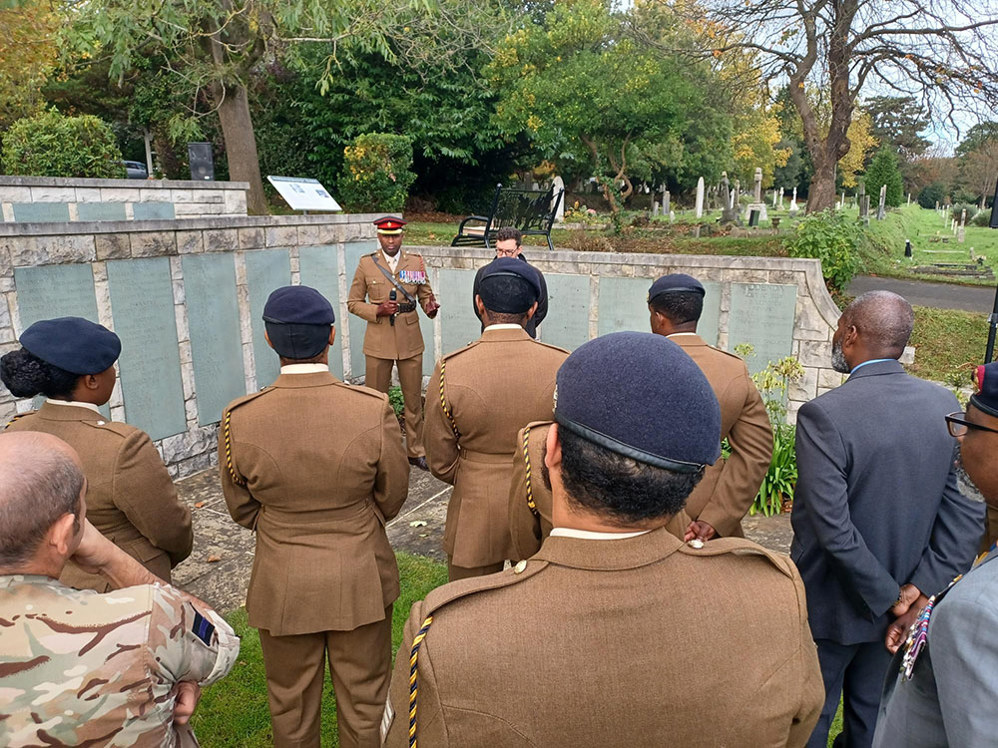 A Black British Army Officer gives a talk to black Army personnel in front of the Hollybrook Memorial.