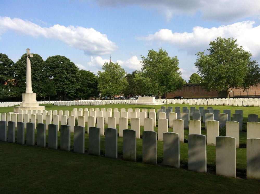 Rows of headstones and Cross of Sacrifice at Ypres Reservoir Cemetery