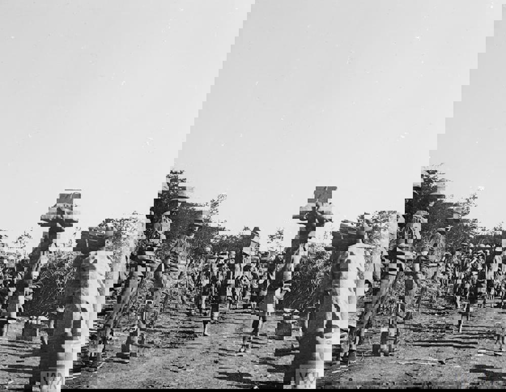 Carriers and labourers hold important supplies while British military officers look on.