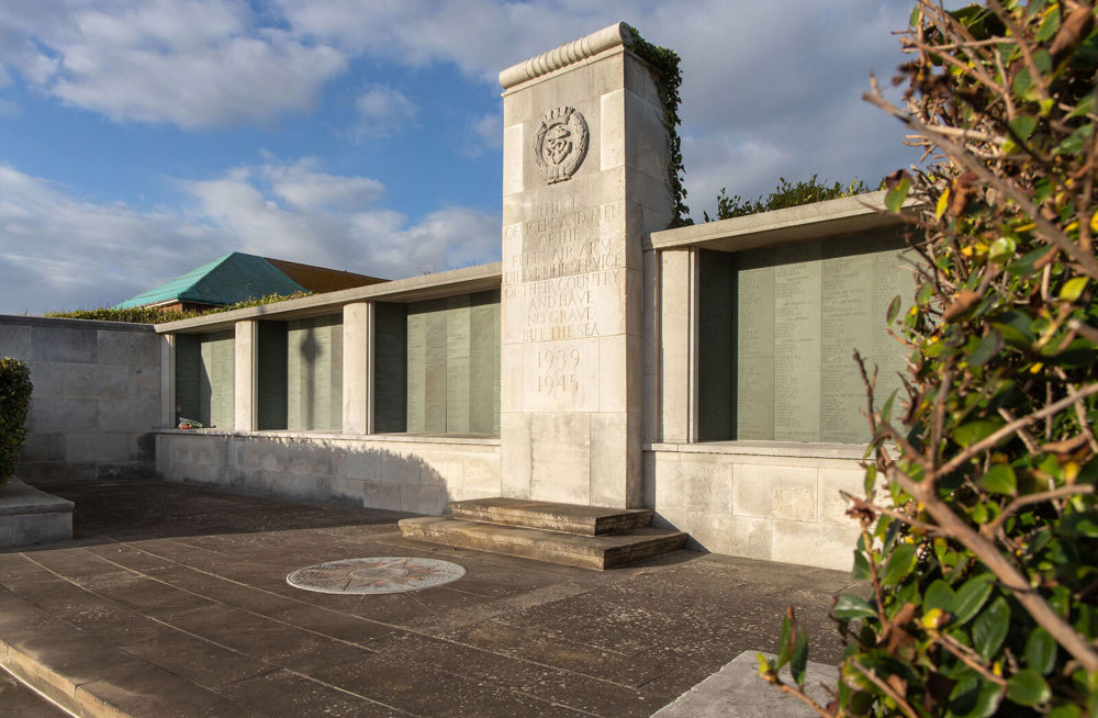 Alternate angle of the Lee-on-Solent Memorial showing central stone pillar decorated with engaved words and embossed Fleet Air Arm regimental insignia. The bronze names panels are held in stone alvoes eminating from the central memorial.