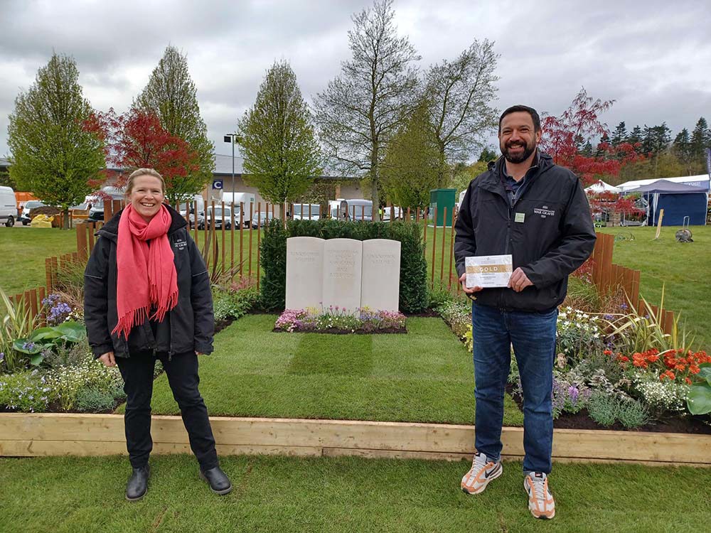 CWGC gardeners posing in front of their winning show garden at the 2024 Harrogate Spring Flower Show.